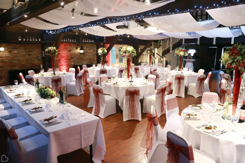 Wedding dinner set up with green and red tones at The Dickens Inn