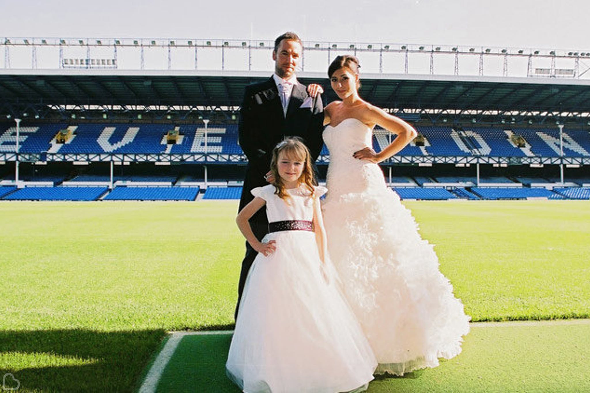 Couple and their daughter pose at the stadium