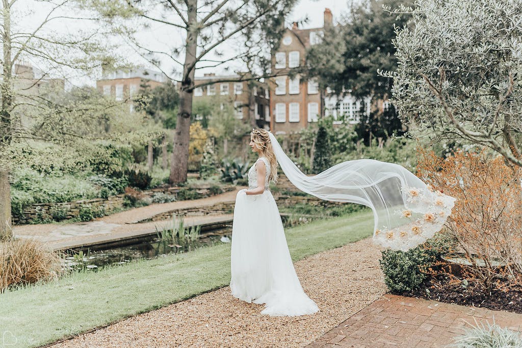 Bride posing in the beautiful autumn gardens.