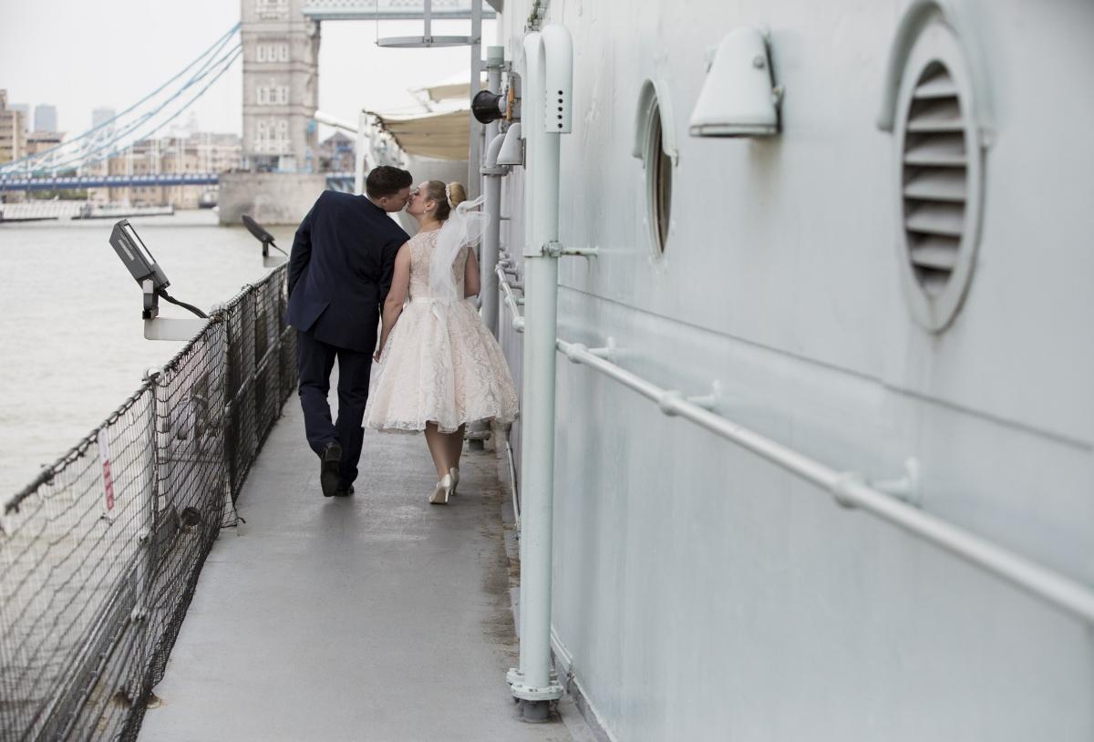 newlyweds kiss outside in the HMS Belfast ship.