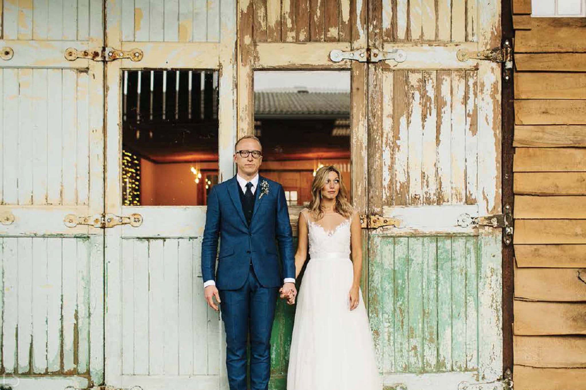 newlyweds pose outside owen house wedding barn