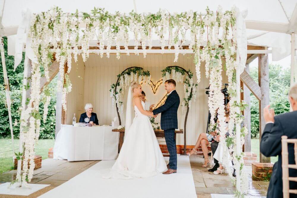 Bride and Groom holding hands at the altar. 