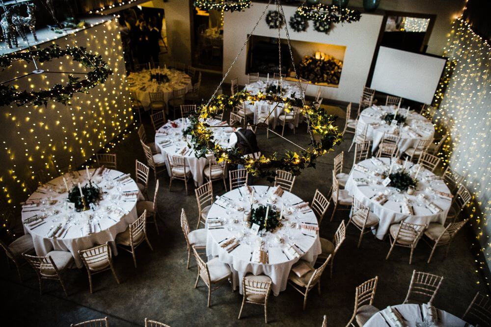 The reception room with white tables set for the dinner.