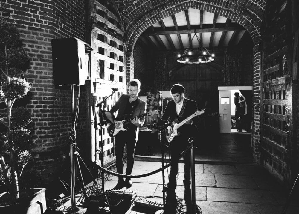 Two members of a band play electric guitar.