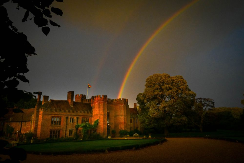 A rainbow is shown across the sky, which appears to end in the manor.