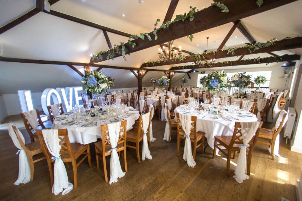 Several tables decorated inside the barn.