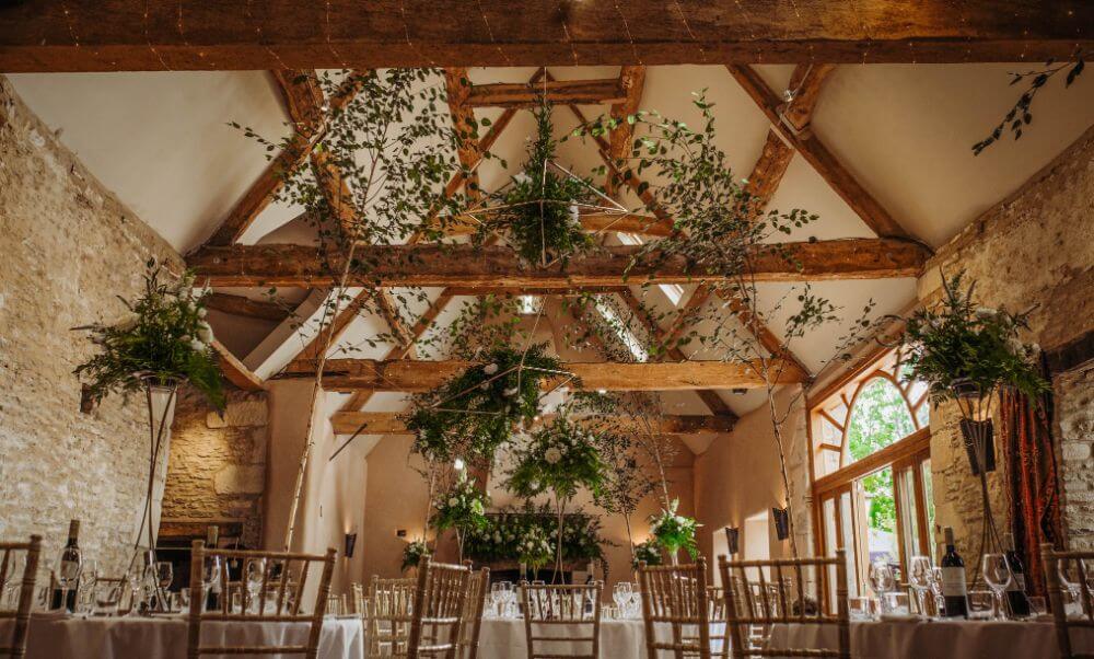 Inside of the venue, the oak beam ceiling is covered in plants.