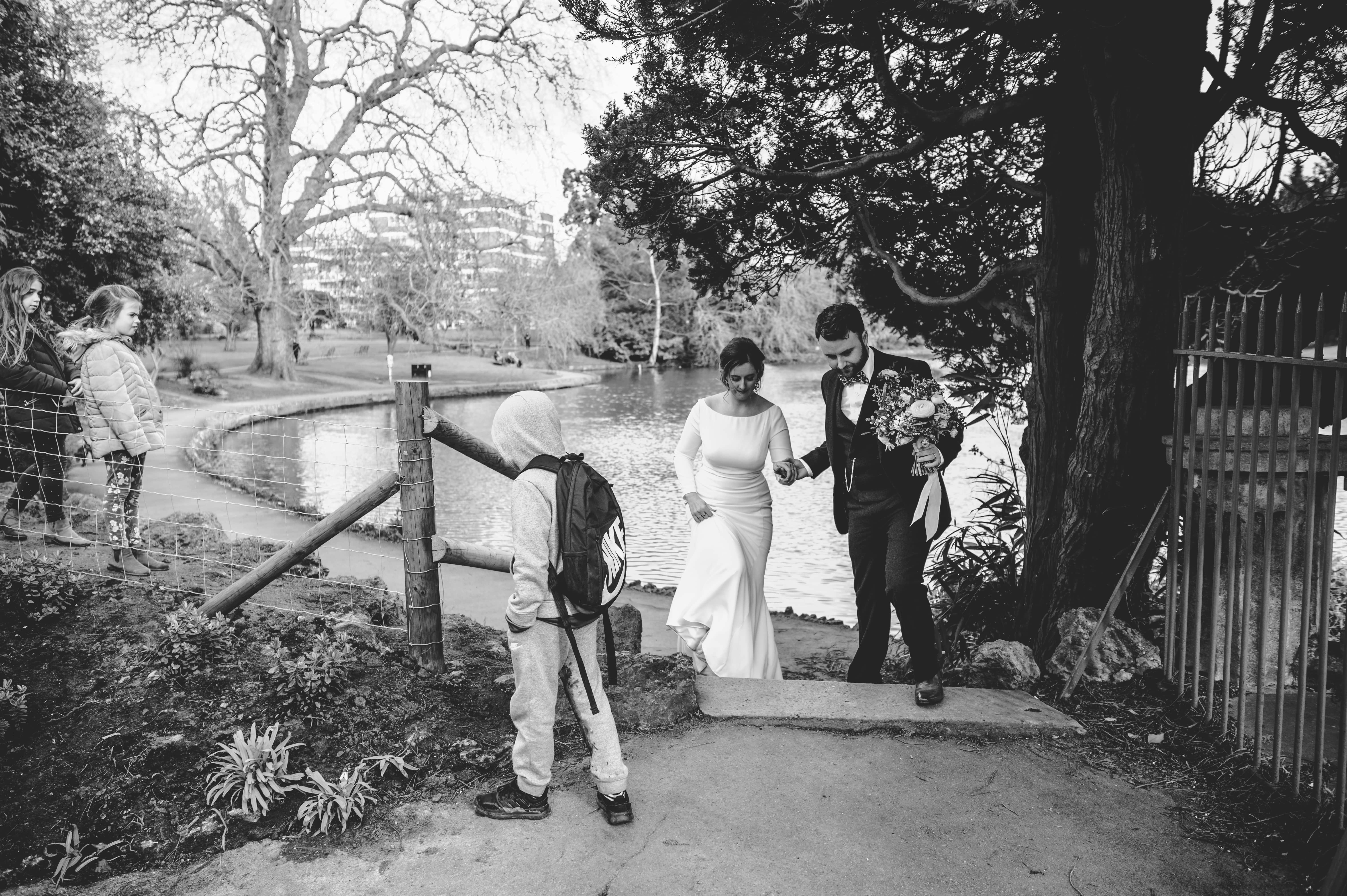 Faye and Adam Hughes walking in a park on their wedding day