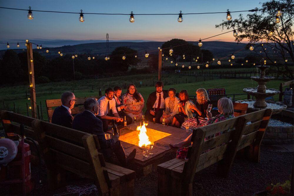 Group of people sitting around a campfire in the evening. 