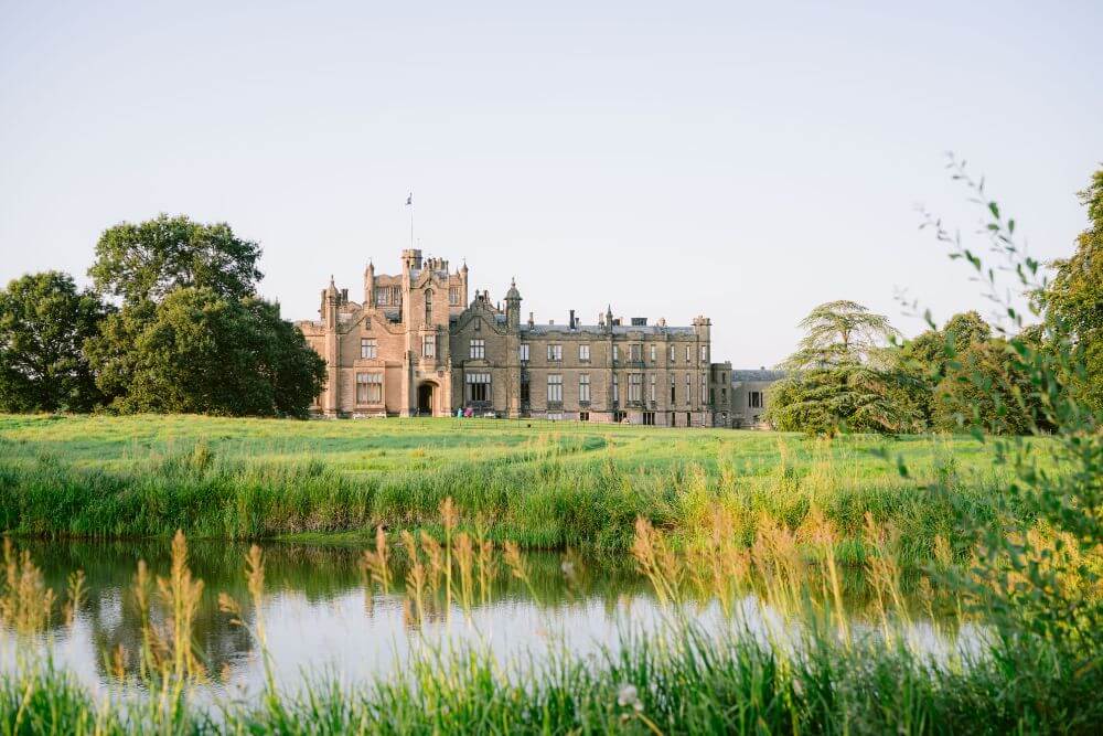 Outside photograph of a castle overlooking a lake.