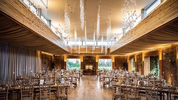 A room set up with chairs, tables and decorations for a wedding reception.
