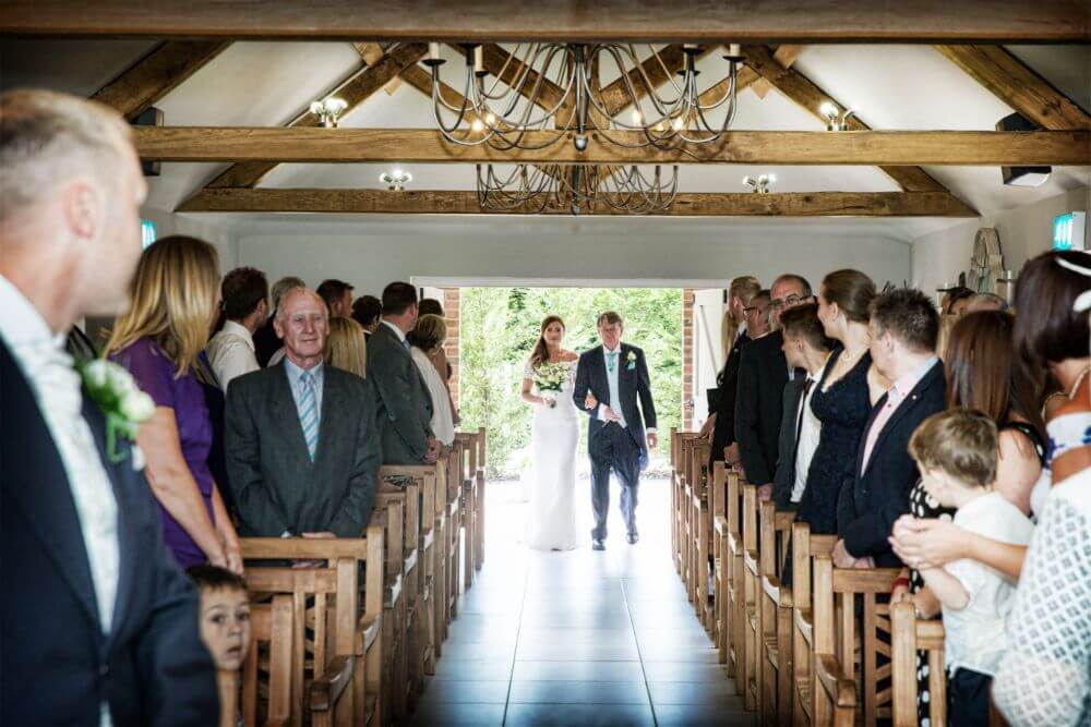 The bride and father of the bride walk down the aisle.