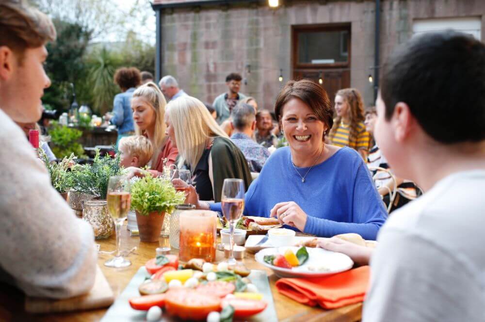 People at the tables smiling and eating.