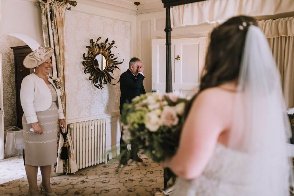 The father of the bride crying and the mother of the bride smiling.