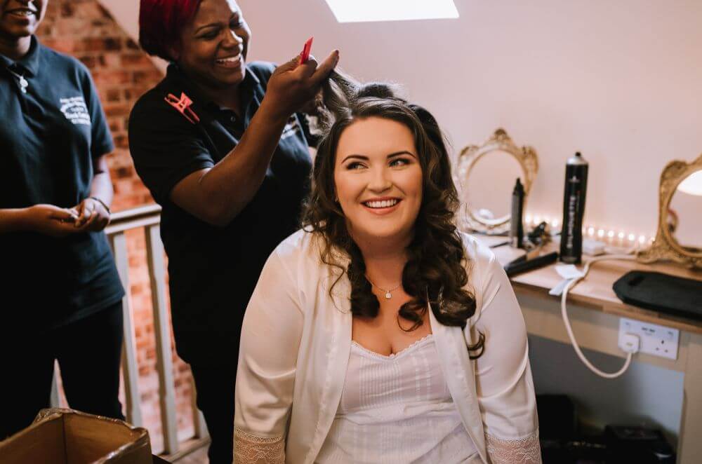 The bride getting her hair done by the hairdresser.