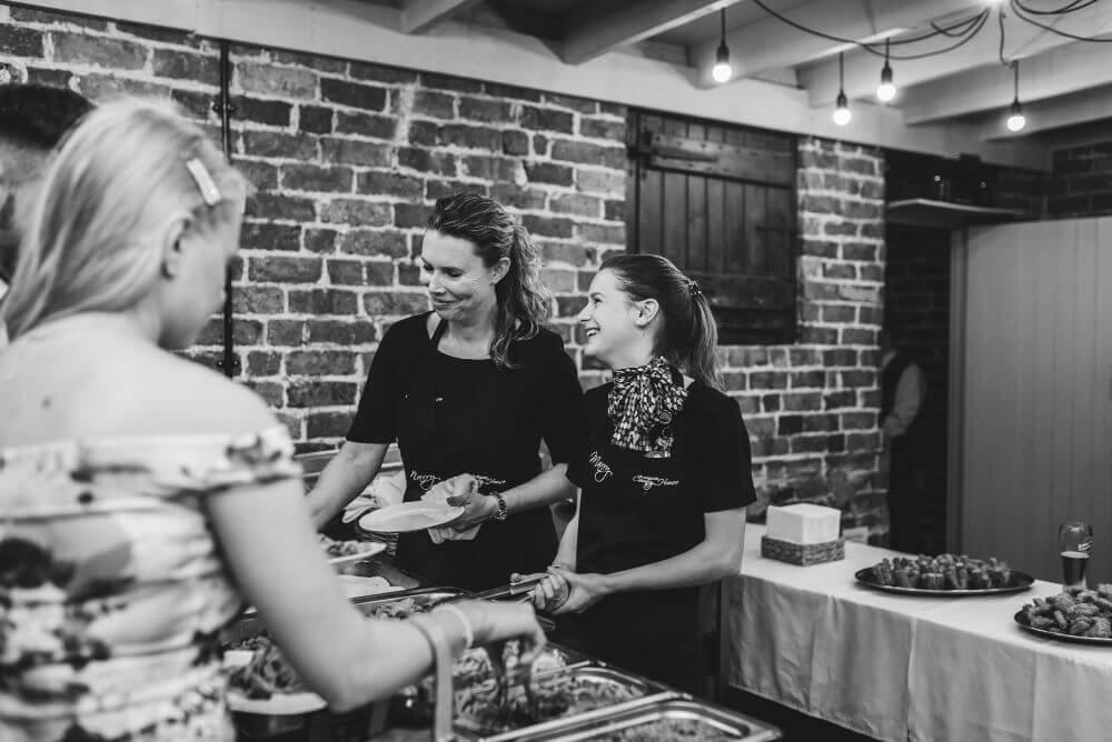 The catering staff smile as they serve the guests.