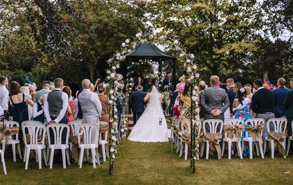 The father of the bride and the bride walk down the aisle.