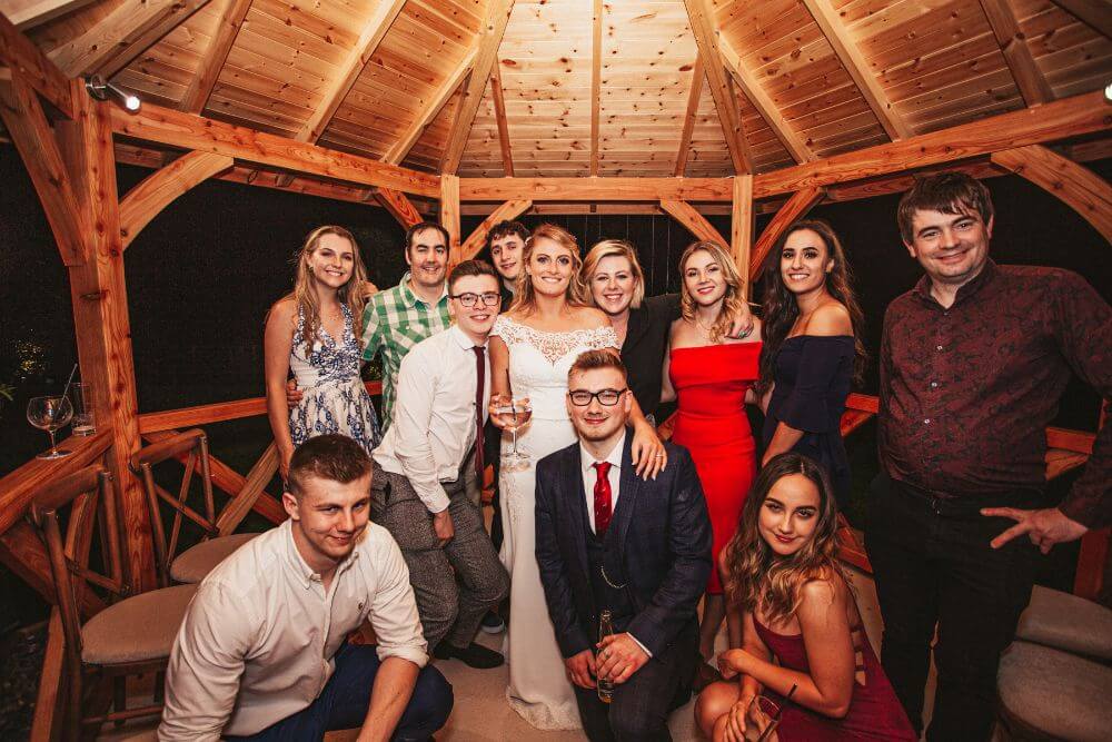 The bride posing with guests inside the gazebo.