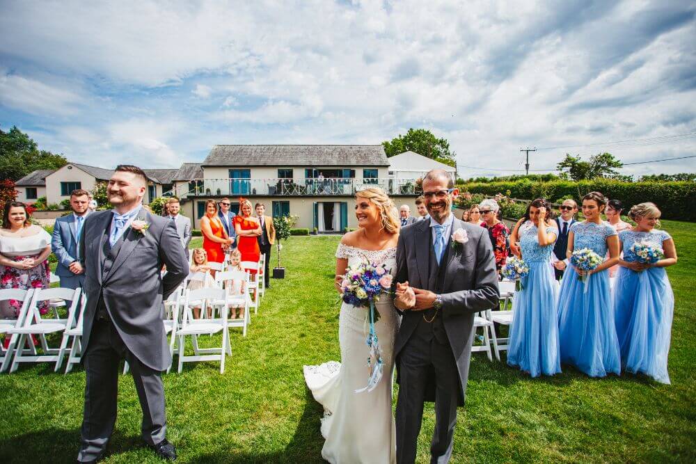 Outside, the ceremony starts with the bride arriving with her father.