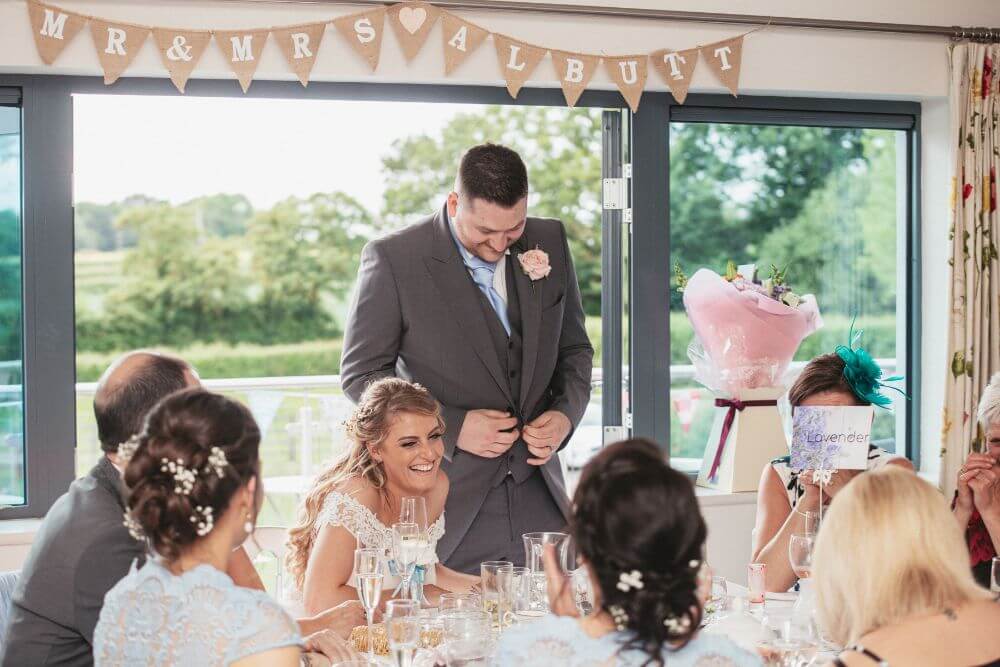 During the reception, the groom says something funny as the bride laughs.