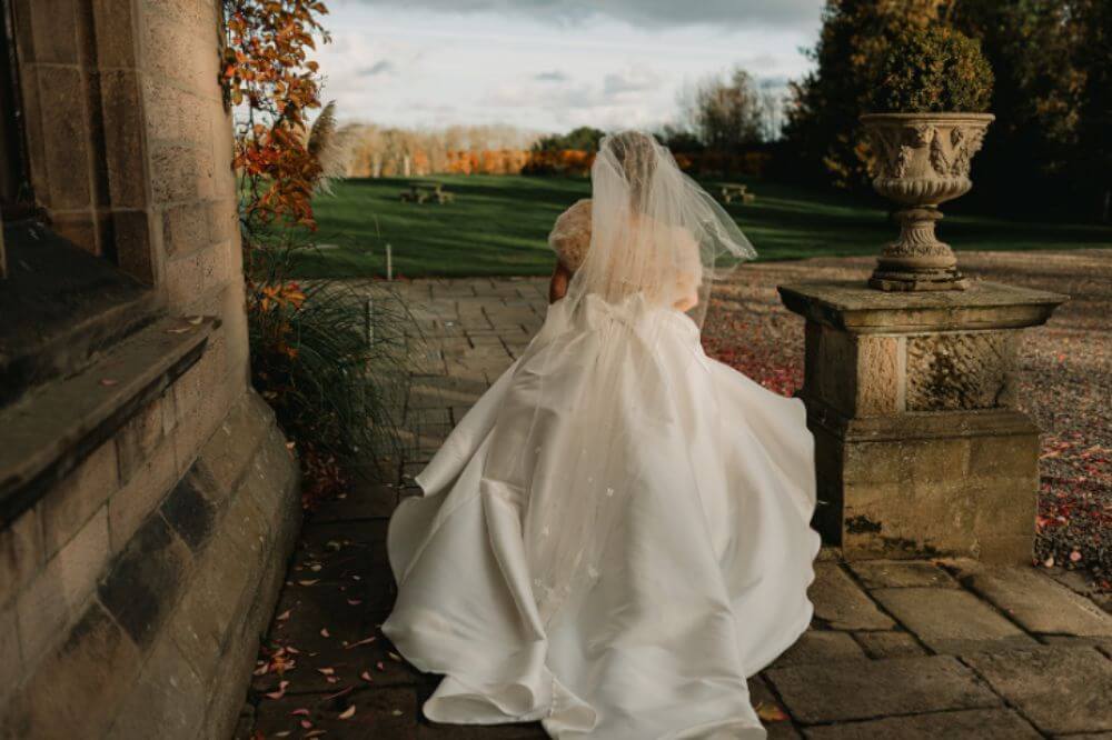 The bride is running outside.