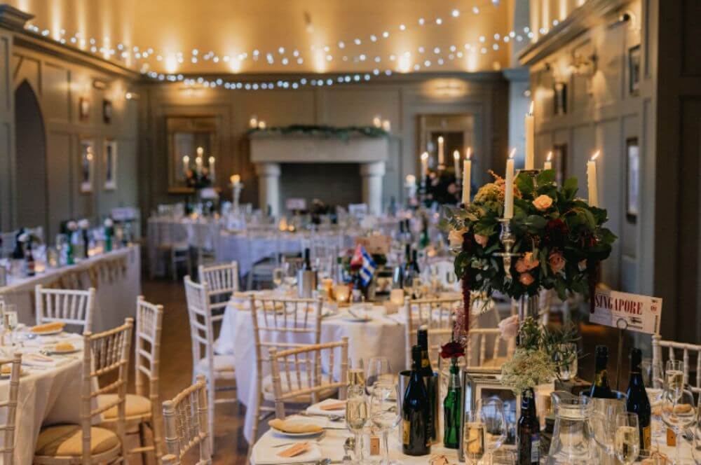 The tables set for dinner inside. Lots of lights in the ceiling.