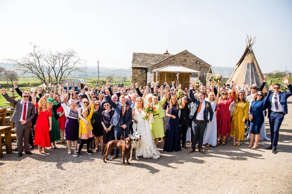 The party guests outside with their hands in the air.