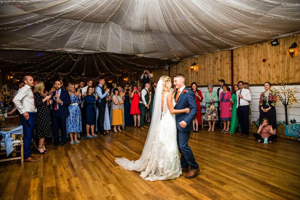 The couple dancing while guests look on.