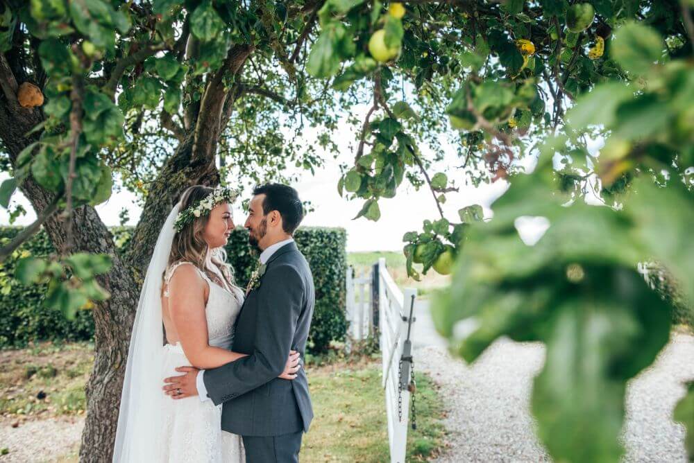 The couple stare lovingly at each other under a lemon tree.