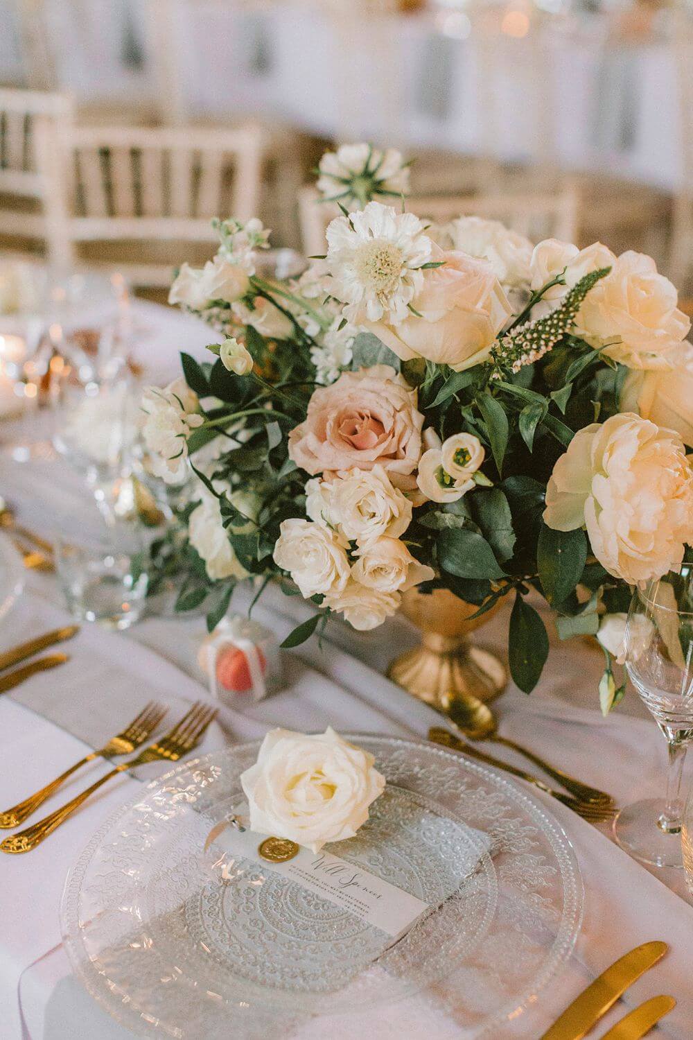 Close up of a jar of roses next to a plate. 
