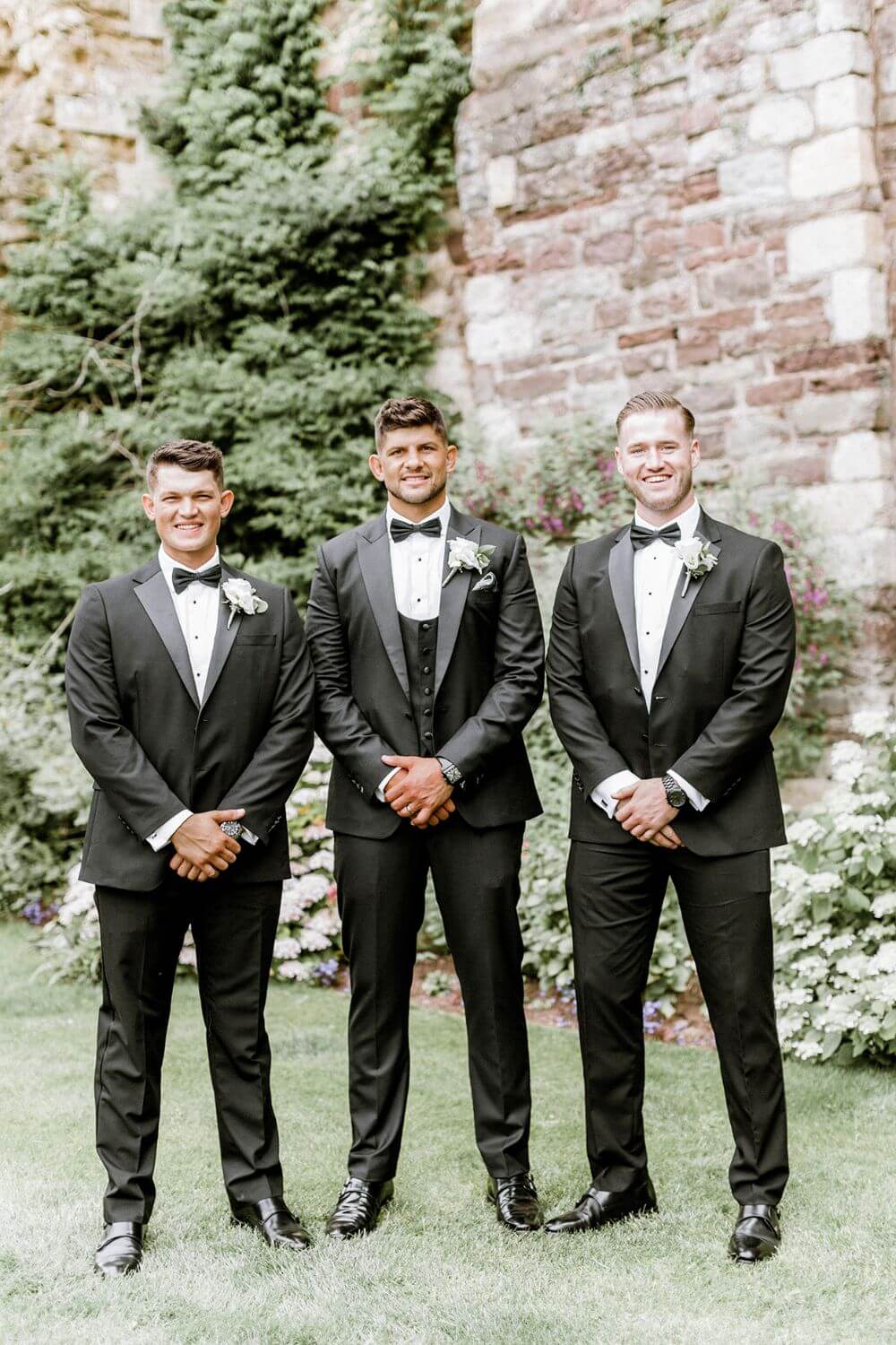 The groom and two groomsmen posing for a photo.