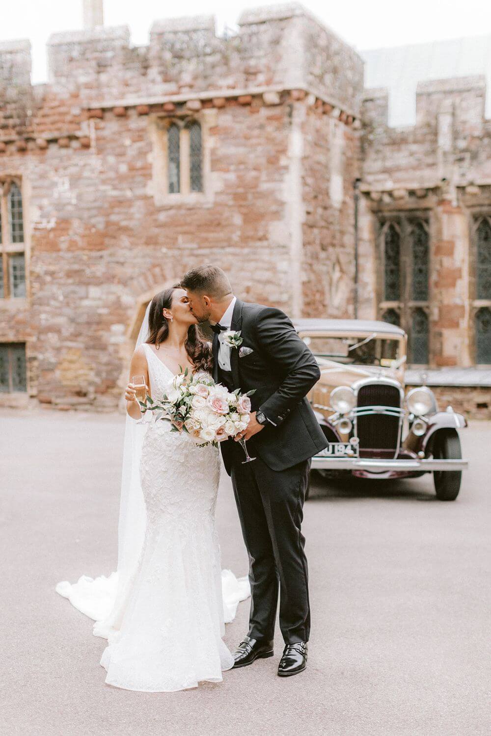 The bride and groom kiss outside the castle. 