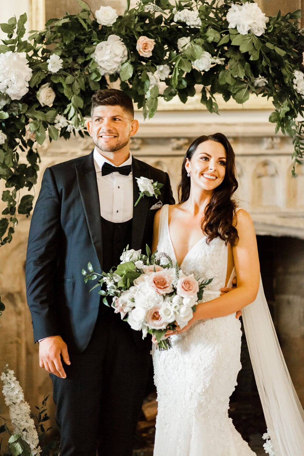 The bride and groom smiling underneath the archway of the ceremony room.