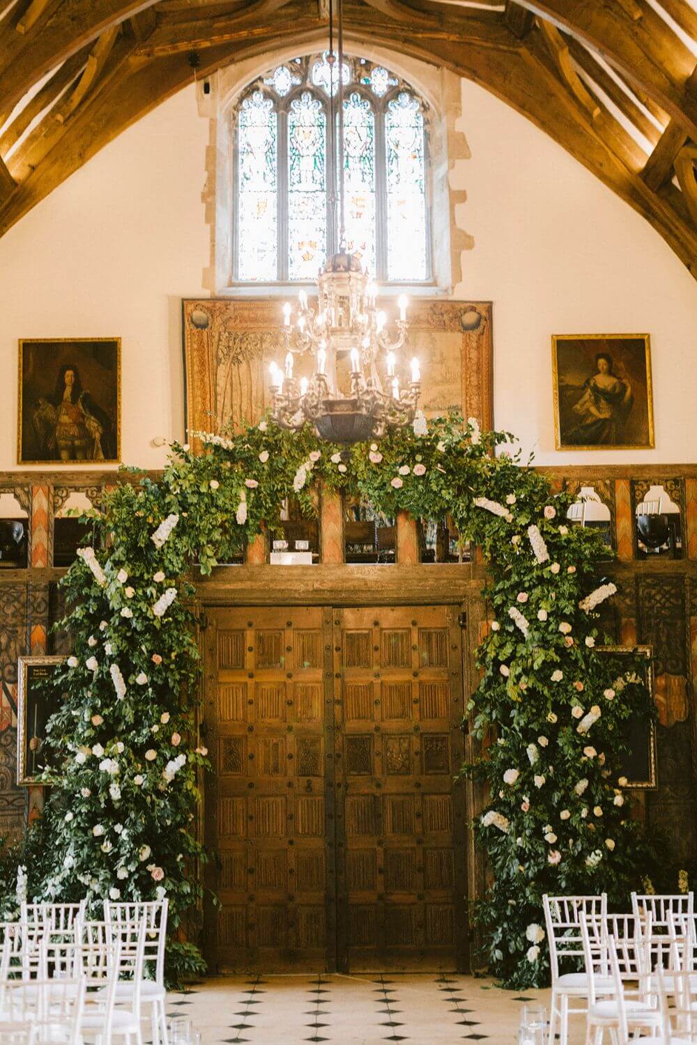 The ceremony room shows an archway covered in white flowers.