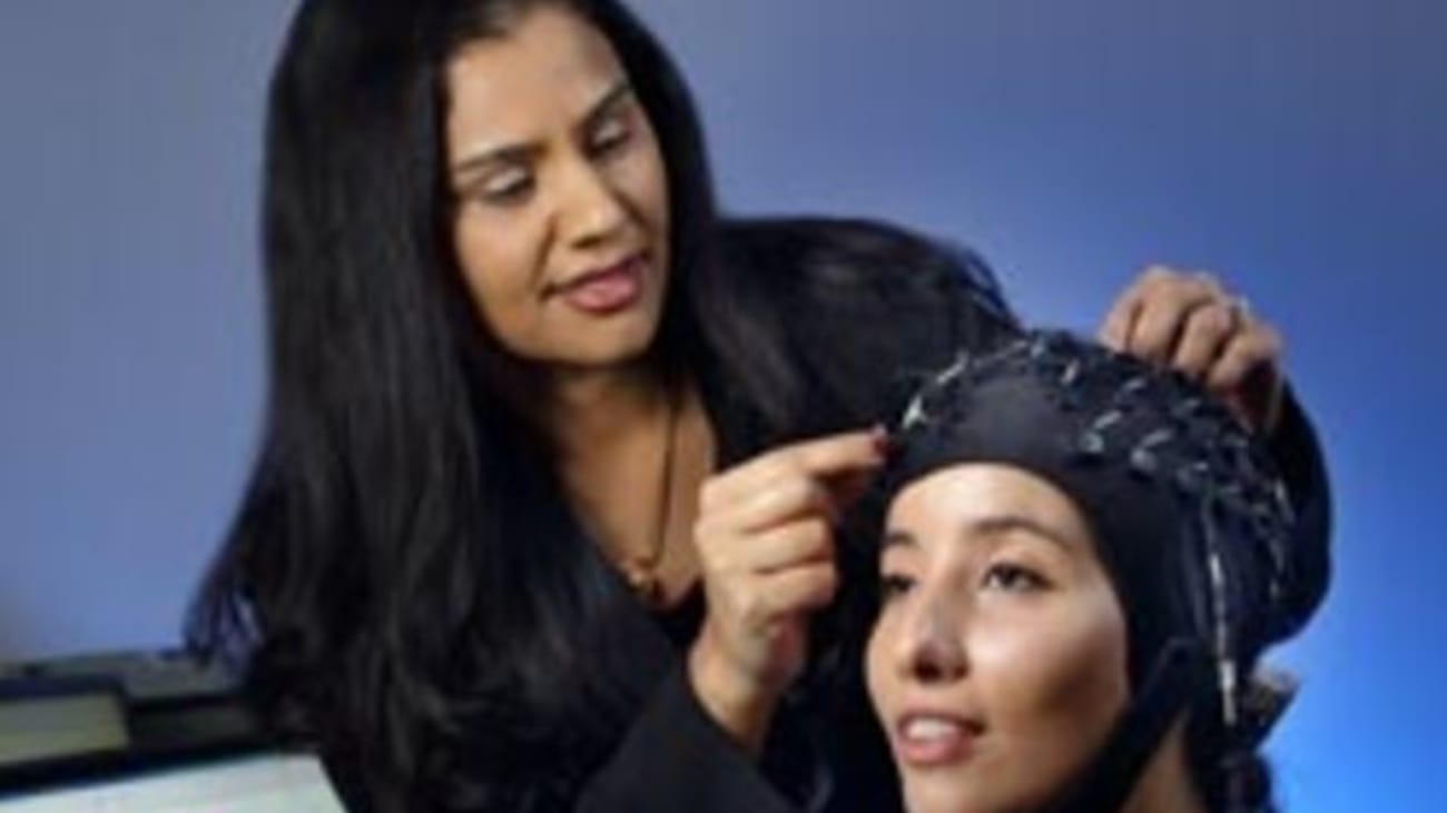 Vidya Kamath adjusts electrodes on a research assistant’s head in preparation for measuring cortical responses in the brain as the subject describes an odor. Sniffin Sticks (foreground) are also used.