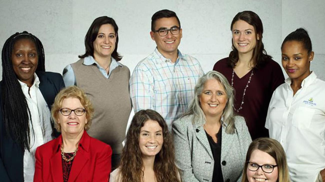 Standing left to right: Kimberly Williams, financial counselor; Jennifer Rice-Assenza, social worker; Fernando Mena-Carrasco, nurse; Caitlin Dowd-Green, pharmacist; and Altheria Burton, patient service coordinator. Sitting and kneeling left to right: Melissa Richardson, care coordination director; Rosalyn Stewart, director; Sophia Pemberton, nurse practitioner; and Heather Dilworth, certified medical assistant.