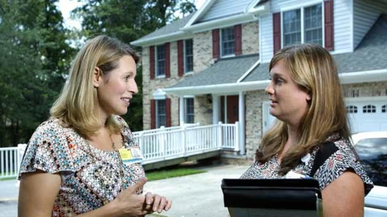 Quincy Samus, left, reviews a patient’s care plan with memory care coordinator Kelly Marshall outside a client’s home.