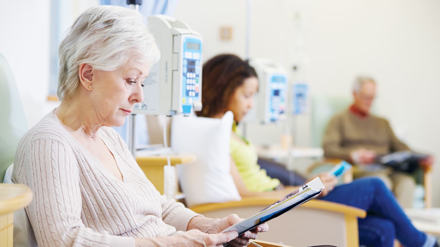 Older patient receiving treatment in an infusion center.