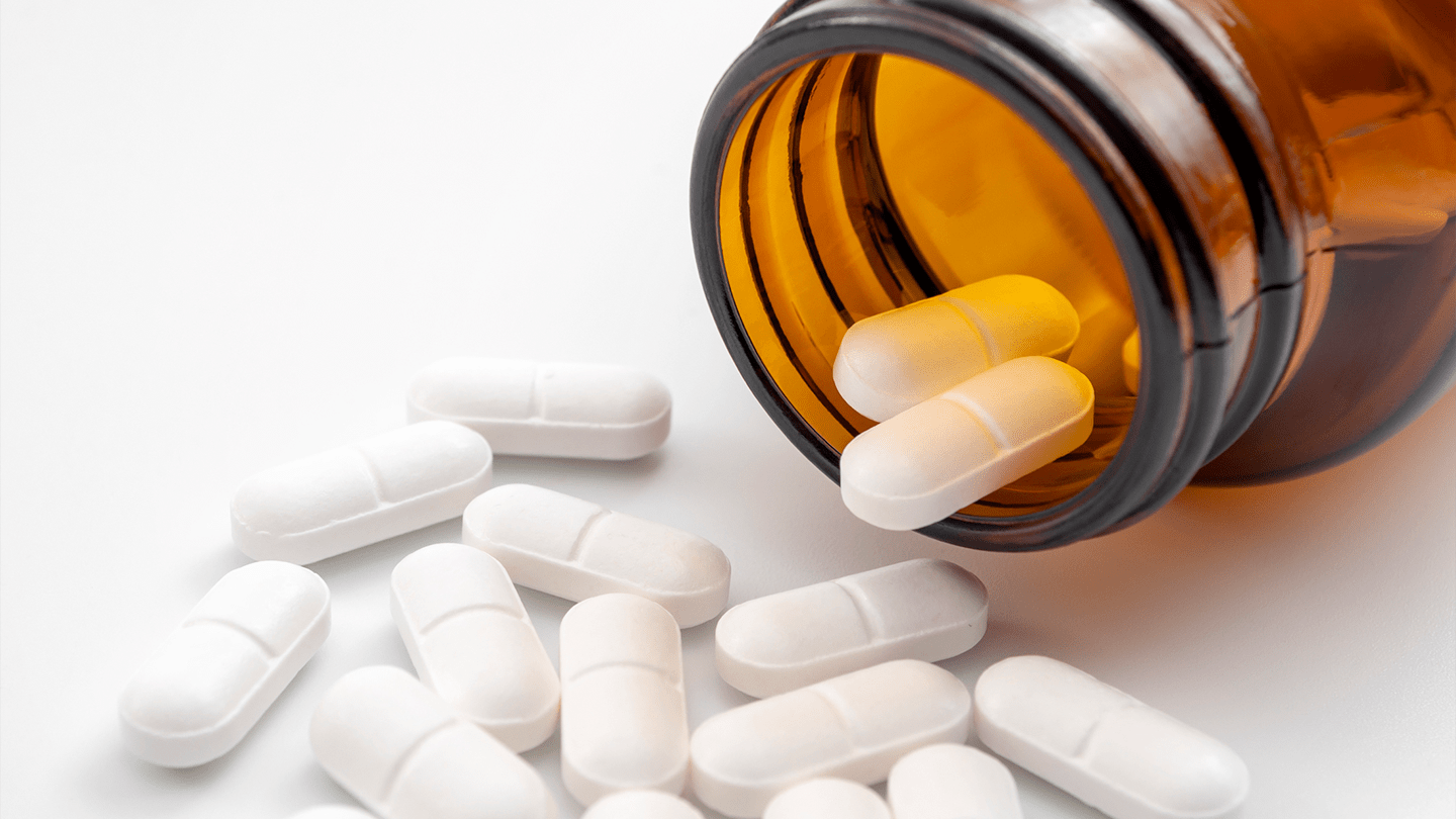 Prescription bottle with white capsules.