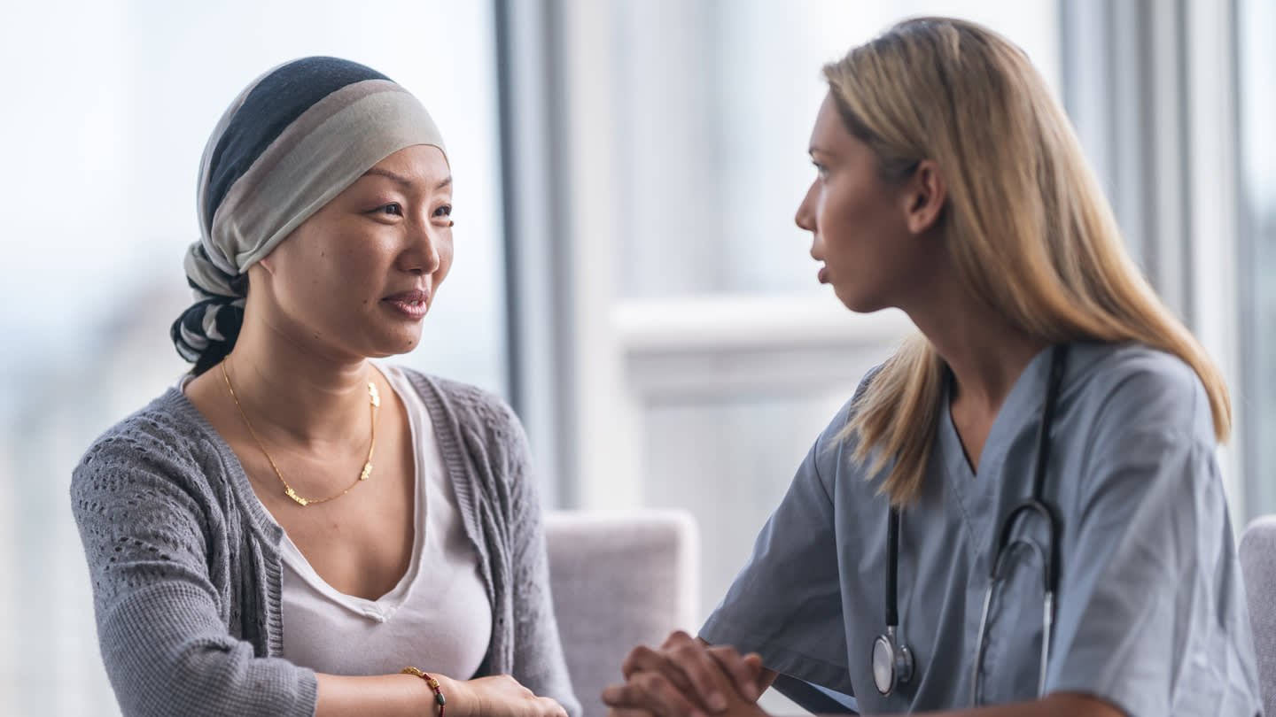 Clinician talking with a patient during a cancer care visit.