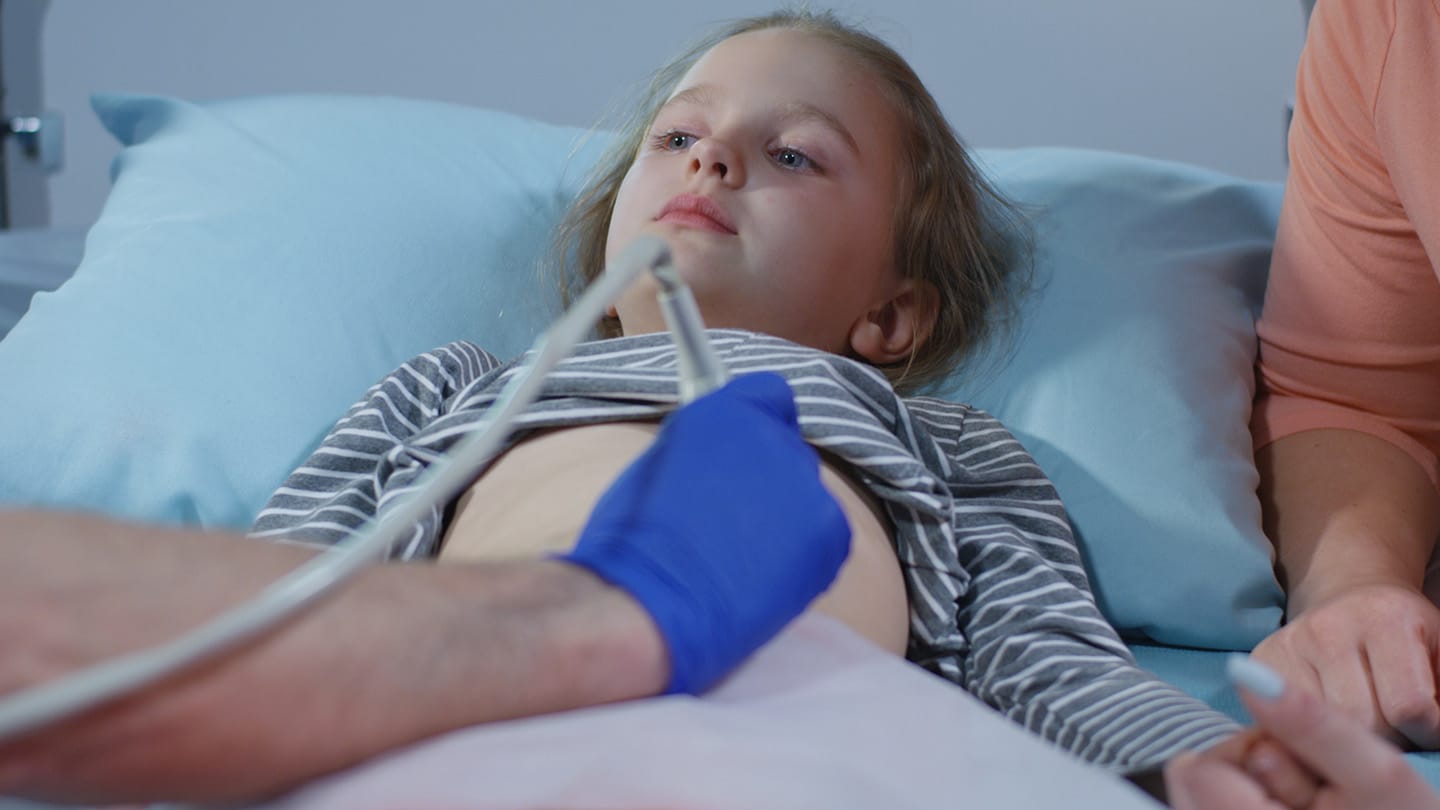 Child in a hospital bed receiving clinical care.