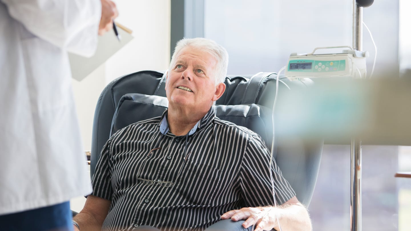 Patient receiving an intravenous infusion with a clinician nearby.