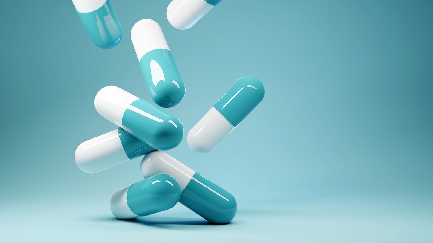 Capsules and tablets on a plain background.