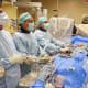 UW Medicine cardiologist Danny Dvir, center of frame, leads a team of UW Medicine heart specialists in performing a never-before-tried technique to replace a patient's failed artificial aortic valve.