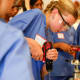 North Texas high schooler Emma Petteway is guided through drilling into a bone by Dr. Alex Callan during a learning event focused on orthopedic surgery and engineering hosted by The Perry Initiative at Scottish Rite for Children in Dallas on Saturday.(Liesbeth Powers / Staff Photographer)