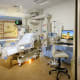 A patient room in the NCCU with a bed, various medical equipment and a desk with a computer and chair