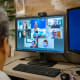 back of a doctors head in an online meeting on a computer with multiple people