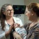 Neonatologist Susan Aucott with a young patient and mom.