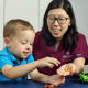 Researchers from Johns Hopkins and the Kennedy Krieger Institute are investigating whether earlier transfers to rehabilitation from the pediatric intensive care unit lead to pediatric patients returning home sooner.  Above, occupational therapist Yun Kim helps a patient improve fine motor skills.