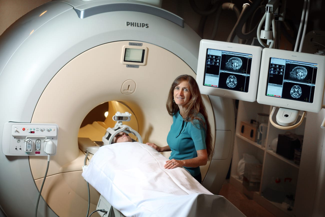 Argye Hillis stands with a patient who is laying down to have an MRI